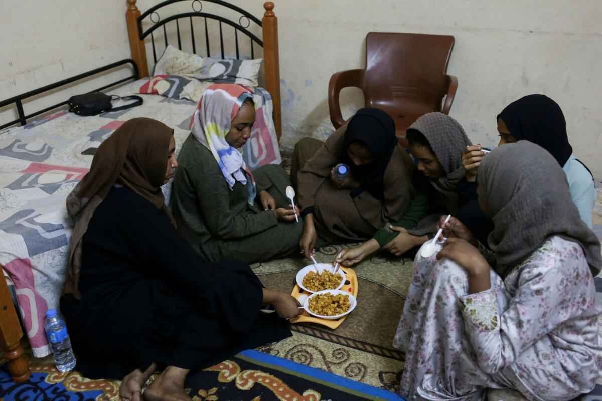 Sudanese displaced women eat in a shelter offered by a Cairo-based centre, after braving a perilous journey from war-ridden Khartoum, in Cairo, Egypt, on May 13, 2023.  Photo: Reuters
