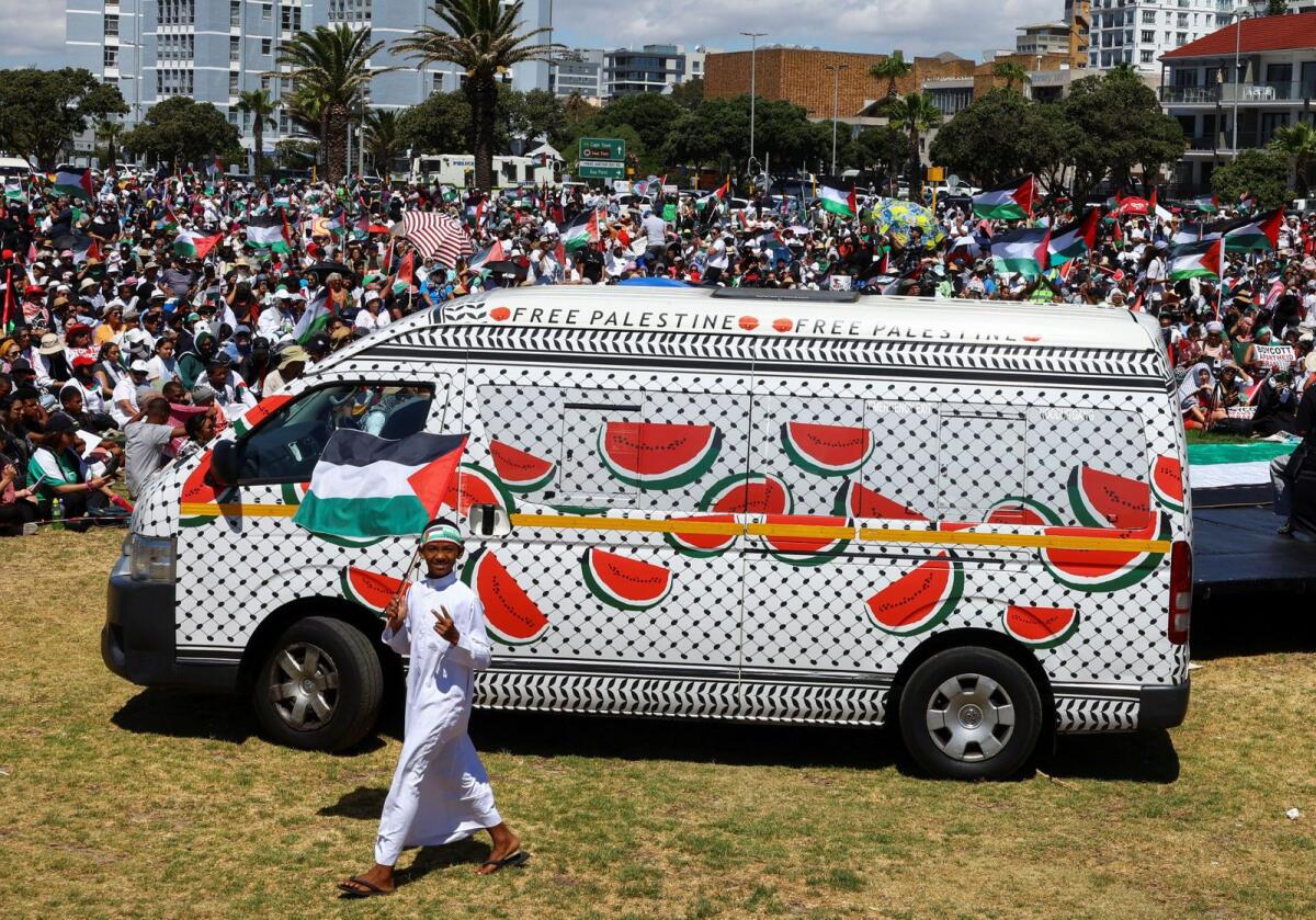 A boy holds a Palestinian flag as he walks past a minibus painted with watermelon in solidarity with the Palestinians at Sea Point promenade during a global day of action amid the ongoing conflict between Israel and the Palestinian Islamist group Hamas, in Cape Town, South Africa, on January 13, 2024. — Reuters