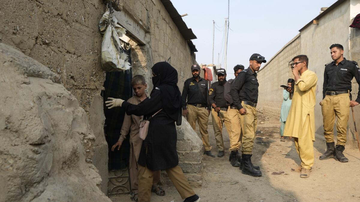 Pakistani police officers conducts biometric identification of a residents during a search operation against illegal immigrants at a neighbourhood of Karachi. — AP