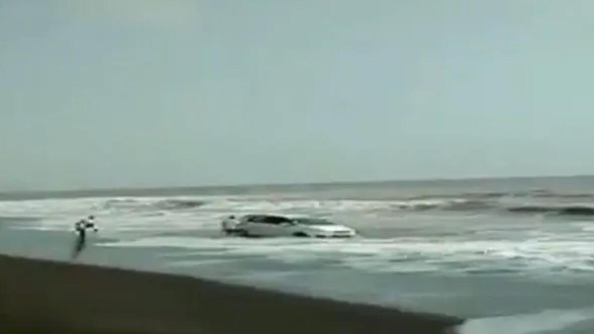 Video: Car stuck in sand gets lashed by sea waves