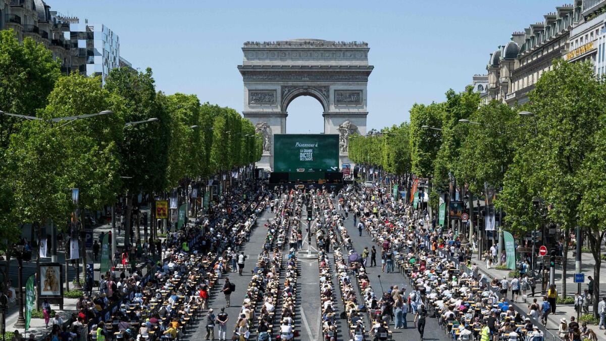 The prestigious Champs-Elysees Avenue transformed into a giant classroom hosting participants as they attempt to beat the record of the 'World's Biggest Dictation' in Paris on Sunday. — AFP