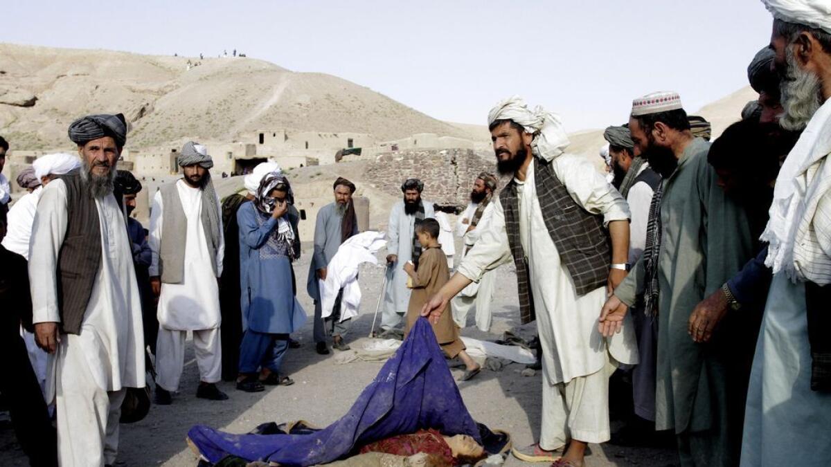 Villagers gather around bodies of children after they were killed by a gas explosion in Heart province, Afghanistan, August 25, 2015. 
