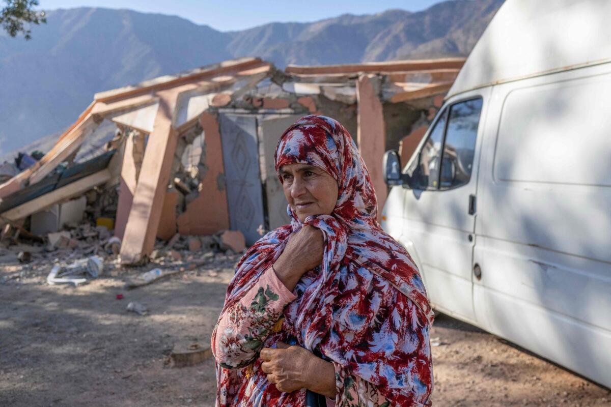 A woman waits as emergency personnel open a road to her village in the mountainous area of Tizi N'Test in the Taroudant province, one of the most devastated in quake-hit Morocco, on Monday. — AFP