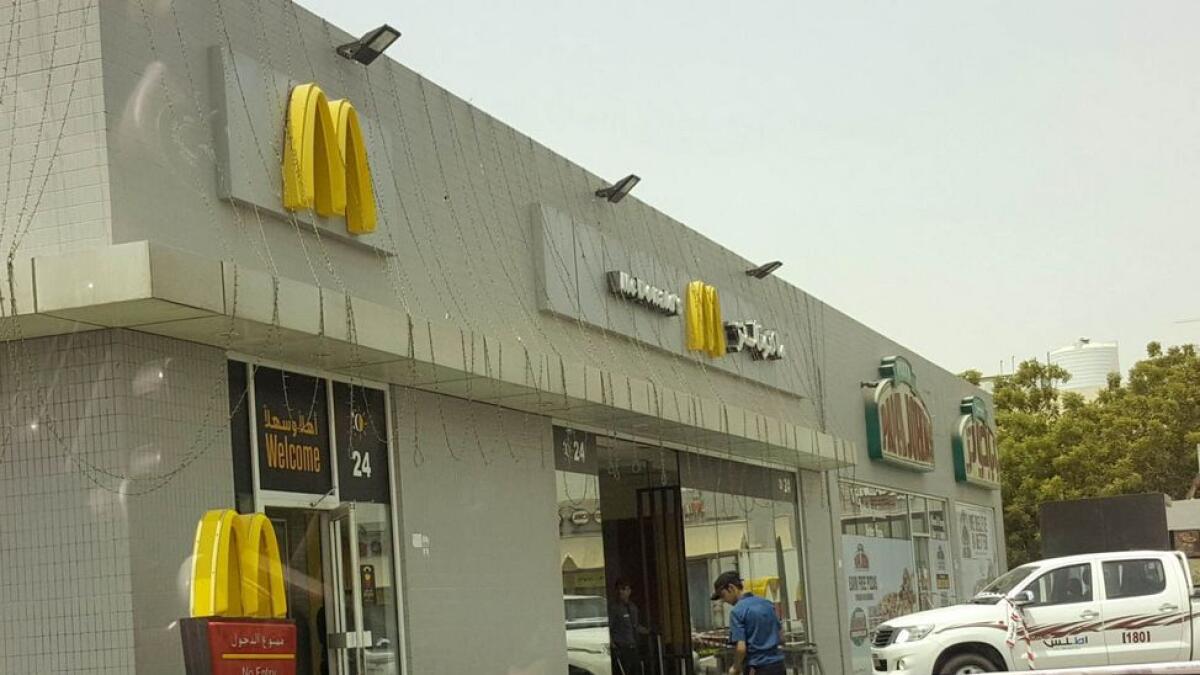 Workers of the McDonald's cleaning the site after the accident that killed two people in Ajman.