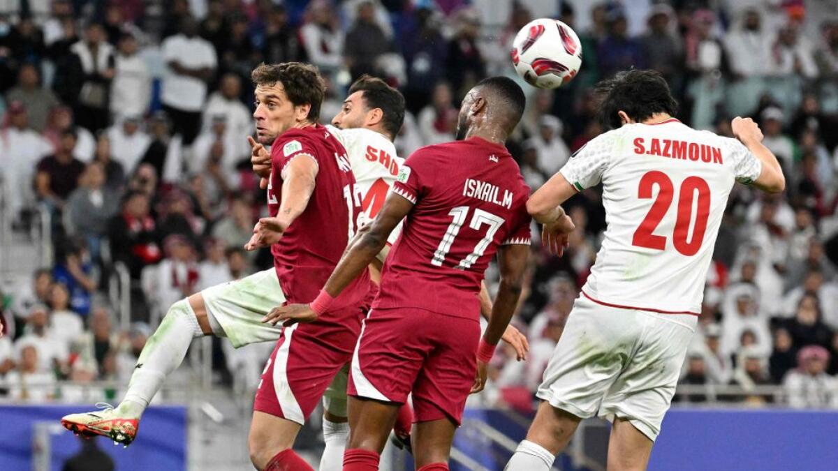 Qatar's defender Ismail Mohammed heads the ball past Iran's forward Sardar Azmoun during the Qatar 2023 AFC Asian Cup semi-final. - AFP