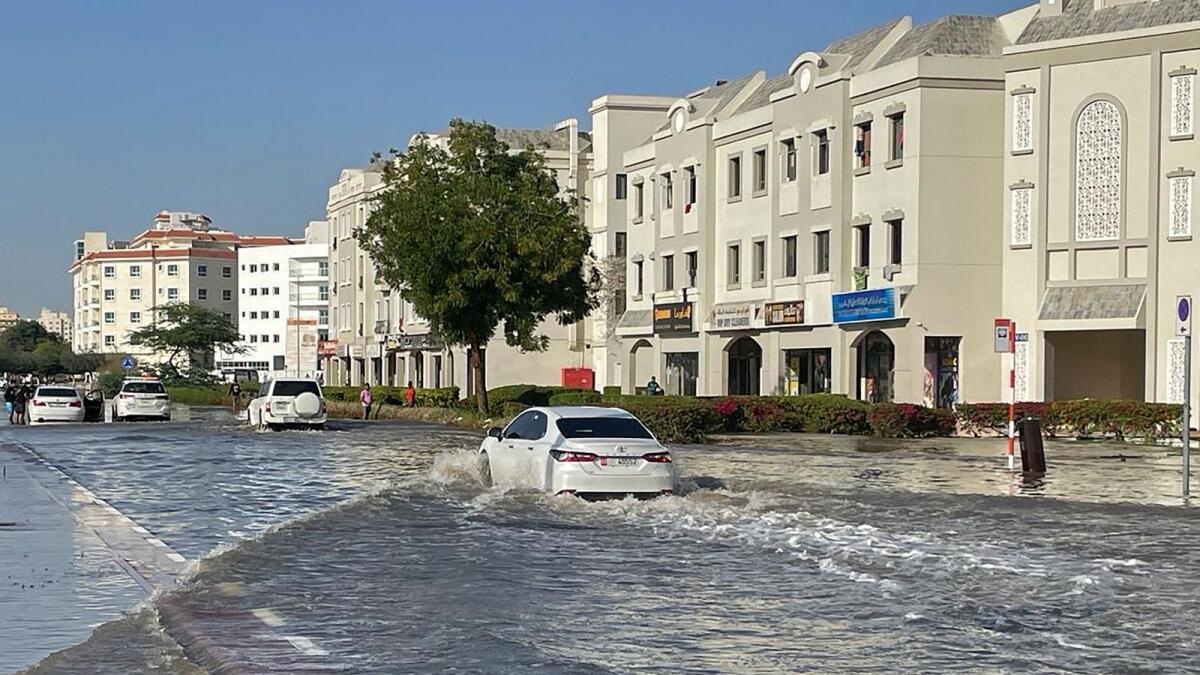 Commuters make their way through a flooded street after heavy rains in Dubai. — AFP