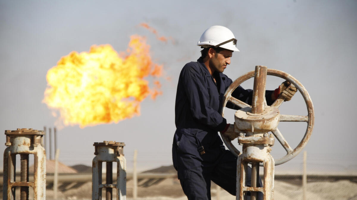 A worker adjusts the valve of an oil pipe at West Qurna oilfield in Iraq's southern province of Basra in this November 28, 2010 file photo. To match Special Report MIDEAST-CRISIS/KURDISTAN     REUTERS/Atef Hassan/Files   (IRAQ  - Tags: BUSINESS ENERGY)