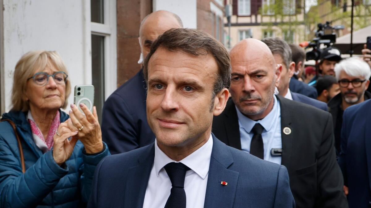 French President Emmanuel Macron walks down a street in Selestat, eastern France, after visiting a factory on Wednesday. — AP file