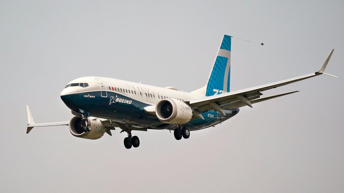 A Boeing 737 MAX jet prepares to land at Boeing Field following a test flight in Seattle. The MAX was grounded worldwide in early March 2019 after the second of two fatal accidents that together killed 346 people aboard almost-new aircraft. — AP file