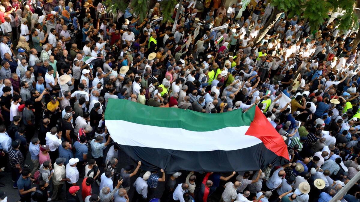 Protestors hold-up a large Palestinian flag during an anti-Israeli demonstration in Tunis. — AFP