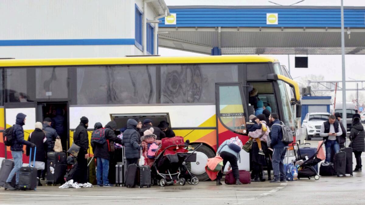 Refugees fleeing war in Ukraine board a bus as they arrive to Palanca, Moldova. — AP