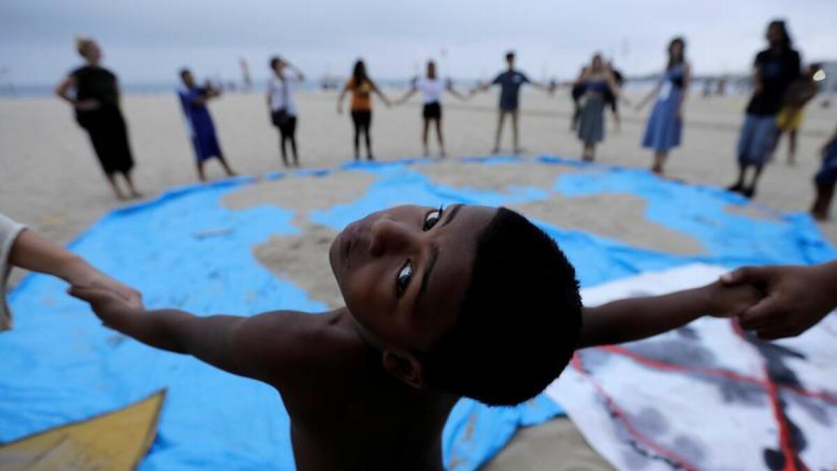 A child and climate change activists attend Extinction Rebellion protests on Copacabana beach in Rio de Janeiro, Brazil October 7, 2019. Reuters