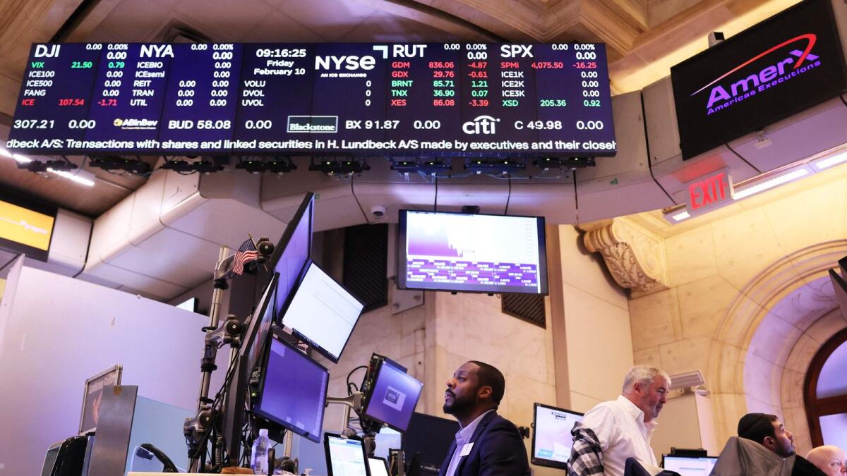 Traders work the floor of the New York Stock Exchange (NYSE) during morning trading on Friday. The stock market opened low this morning continuing a week of losses by Dow Jones, Nasdaq and the S &amp; P 500 which is heading to its worst week in almost two months.  - AFP