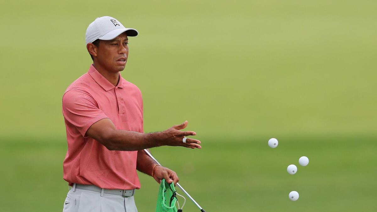 Tiger Woods tosses golf balls on the practice range at Augusta National Golf Club, in Augusta. — AP