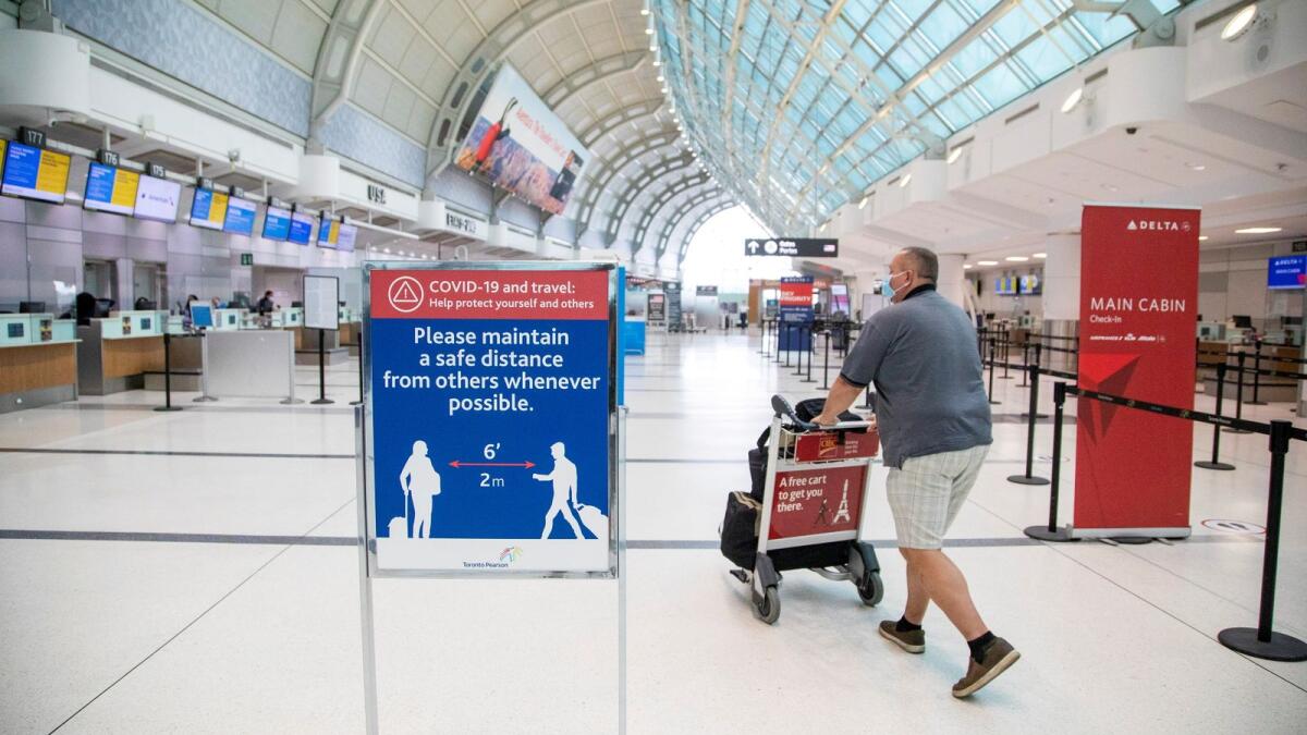 A man pushes a baggage cart at Toronto Pearson International Airport in Toronto, Ontario, Canada. — Reuters file