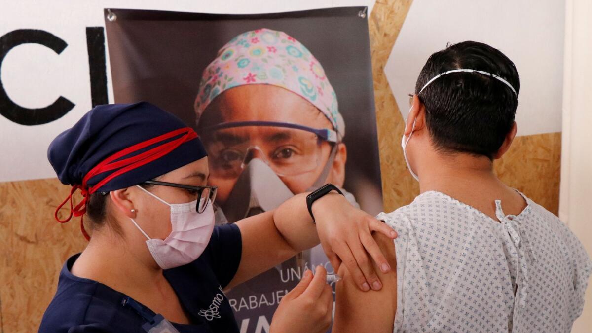 A volunteer receives an injection from a medical worker from Chinese pharmaceutical company CanSino Biologics Inc. for a late stage-trial against the coronavirus disease (COVID-19), in Oaxaca, Mexico November 6, 2020.