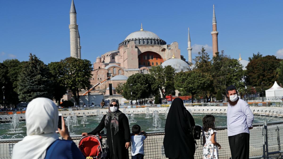 Women take pictures in front of Hagia Sophia or Ayasofya-i Kebir Camii in Istanbul, Turkey. Photo: Reuters
