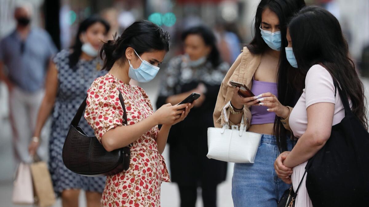 Shoppers stand together on Oxford Street, in London. New rules on wearing masks in England have come into force, with people going to shops, banks and supermarkets now required to wear face coverings. Police can hand out fines of 100 pounds ($127) if people refuse, but authorities are hoping that peer pressure will prompt compliance. Photo: AP