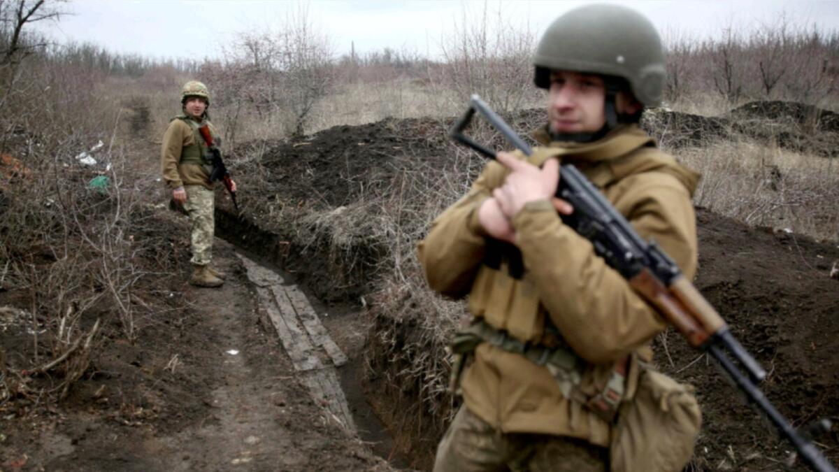Ukrainian servicemen patrol along a position at the front line with Russia-backed separatists not far Avdiivka, Donetsk region. — AFP
