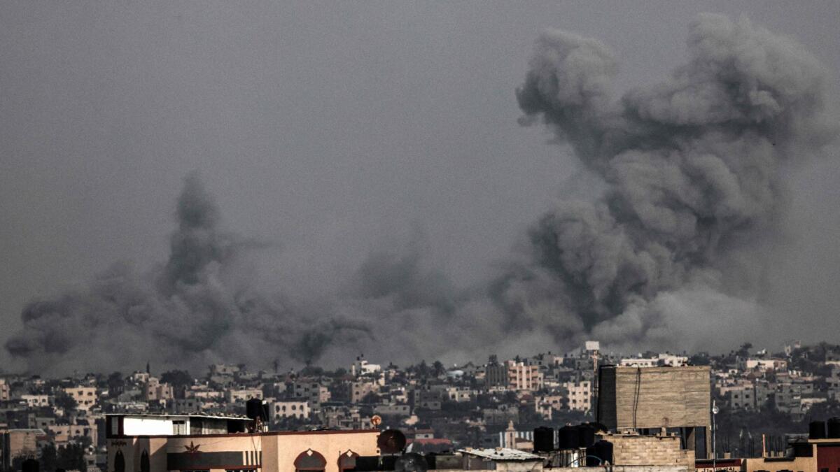 A picture taken from Rafah shows smoke billowing above buildings during Israeli bombardment on Khan Yunis in the southern Gaza Strip on Saturday. — AFP