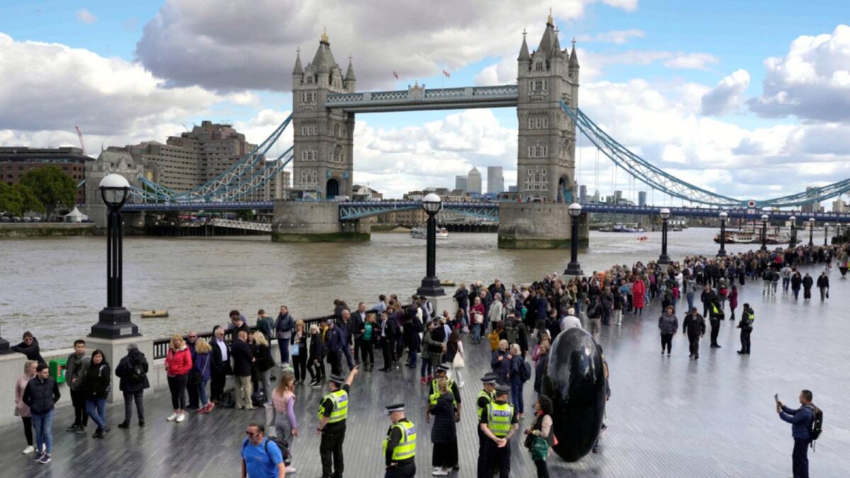 People walk in a queue in front of Tower Bridge to pay their respects to the late Queen Elizabeth II during the Lying-in State at Westminster Hall. — AP