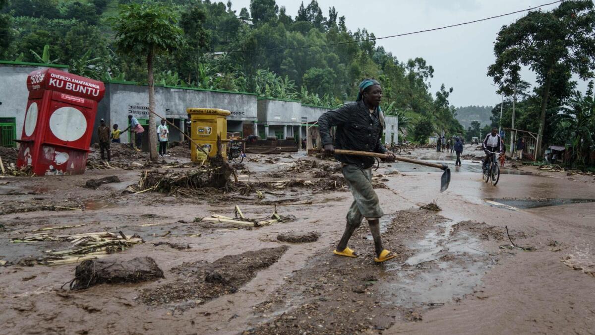 A man removes debris from the road after the flood killed 10 people at the village of Bupfune near Kibuye, in Rwanda's Western Province, on May 4. Rwandans grieved for lost loved ones and destroyed homes after powerful floods and landslides tore through the country killing at least 130 people and leaving many thousands homeless. — AFP