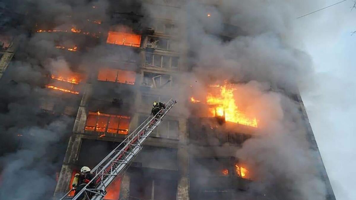 In this handout picture taken and released by the State Emergency Service of Ukraine on March 15, 2022, firemen work to extinguish a fire in a housing block hit by shelling in the Sviatoshynsky district in western Kyiv. Photo: AFP
