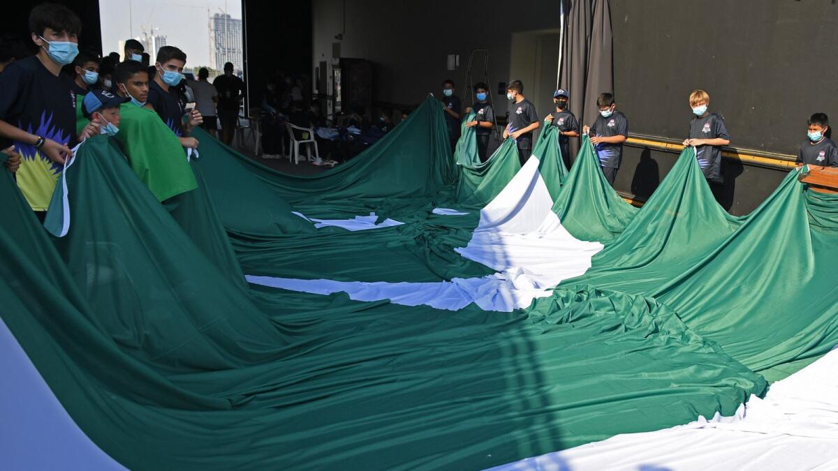 Flag boys hold Pakistan's national flag as they rehearse before the start of the ICC men’s Twenty20 World Cup cricket match between India and Pakistan at the Dubai International Cricket Stadium in Dubai on October 24, 2021. (Photo: AFP)