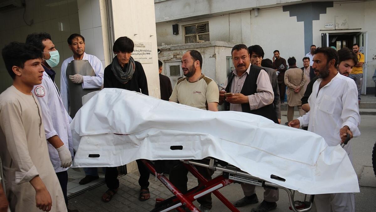 Afghan volunteers carry a dead body on a stretcher to a hospital following a suicide attack in Kabul.- AFP