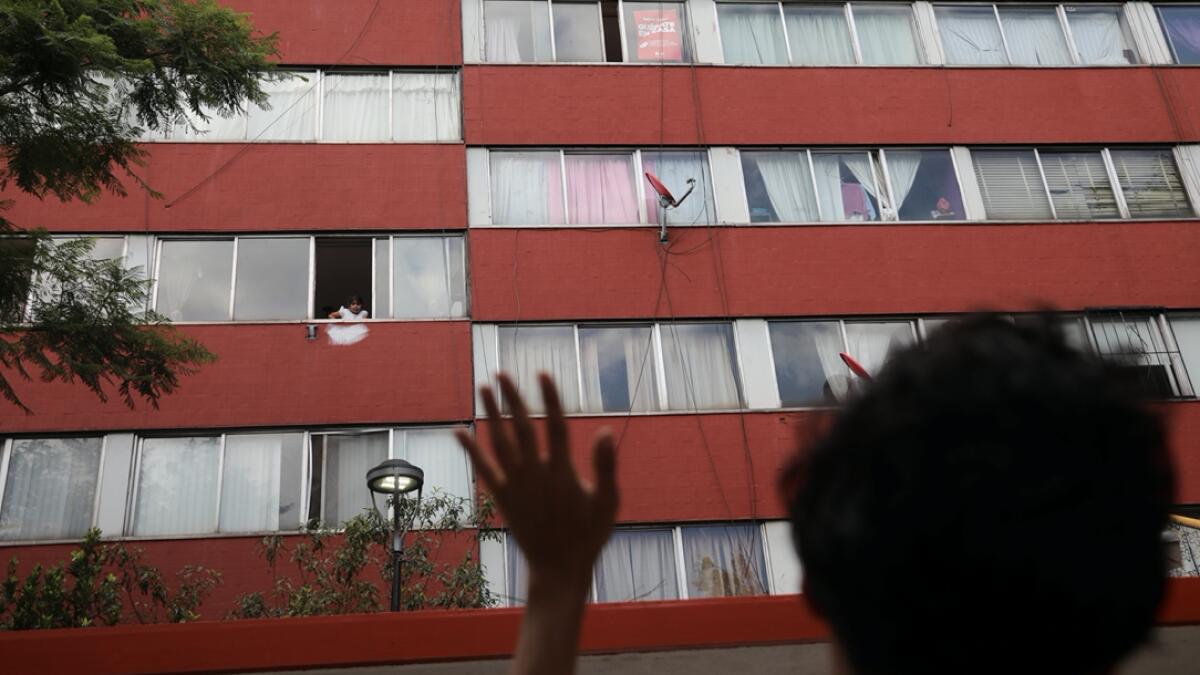 Mexican architect Percibald Garcia greets to children as he reads aloud a different story from a book every day to children stuck at home in an apartment complex, as the coronavirus disease (Covid-19) outbreak continues, in the Tlatelolco neighbourhood in Mexico City, Mexico. Photo: Reuters