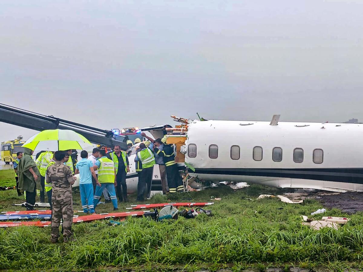 Officials gather around a damaged aircraft after it veered off the runway amid heavy rains, in Mumbai, Thursday, Sept. 14, 2023. Photo: PTI