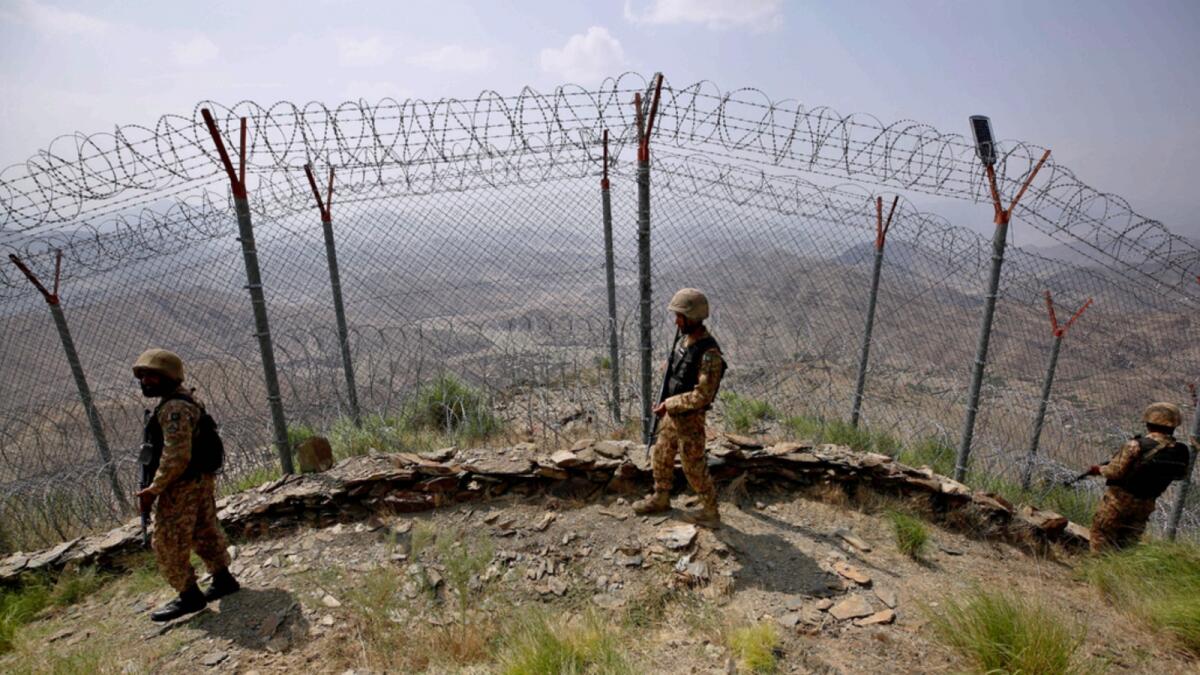 Pakistan Army troops patrol along the fence on the Pakistan Afghanistan border at Big Ben hilltop post in Khyber district, Pakistan. — AP