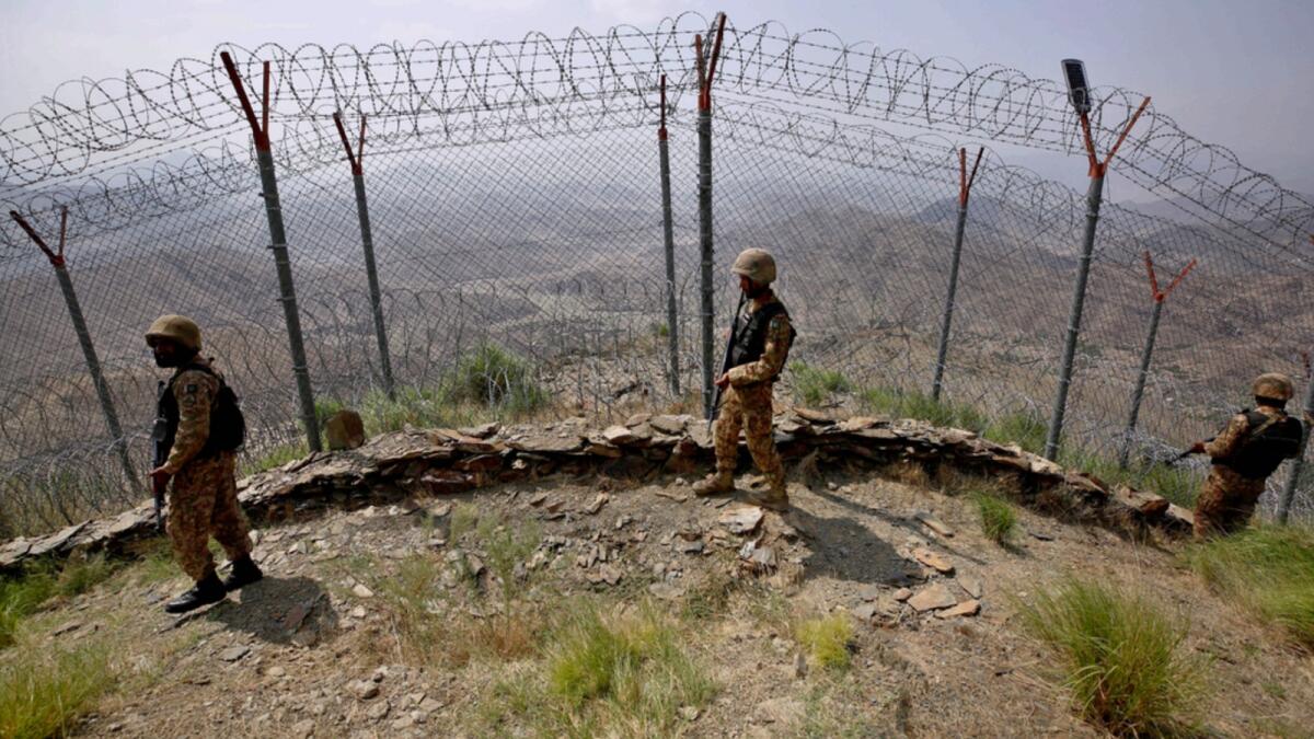 Pakistan Army troops patrol along the fence on the Pakistan Afghanistan border at Big Ben hilltop post in Khyber district, Pakistan. — AP