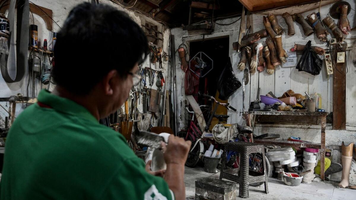 Former leprosy patient Ali Saga making prosthetic legs and hands inside his workshop in Tangerang to help people with disabilities to have access to artificial limbs at affordable prices. — AFP