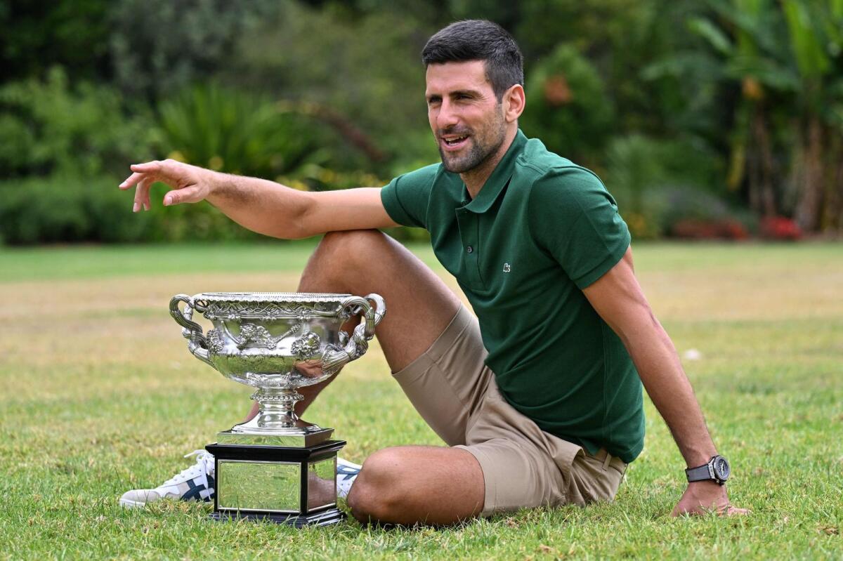 Novak Djokovic poses with the Norman Brookes Challenge Cup trophy at the Government House a day after his victory against Stefanos Tsitsipas in the final of the Australian Open. -- AFP
