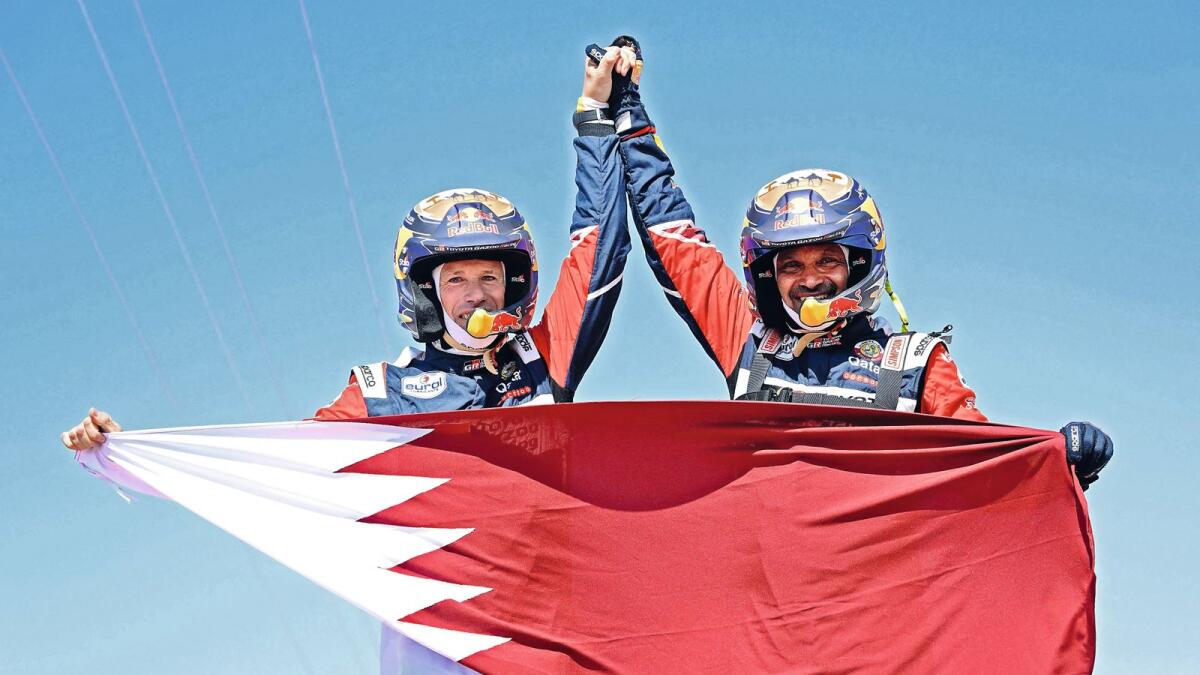 Qatar's Nasser Al Attiyah of Qatar (right) and his co-driver Mathieu Baumel of France celebrate their victory  after winning the Dakar Rally in Jeddah, Saudi Arabia, on Friday. — AFP