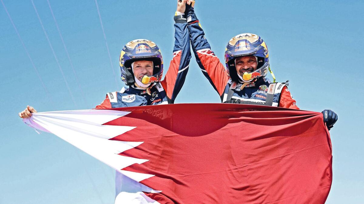 Qatar's Nasser Al Attiyah of Qatar (right) and his co-driver Mathieu Baumel of France celebrate their victory  after winning the Dakar Rally in Jeddah, Saudi Arabia, on Friday. — AFP