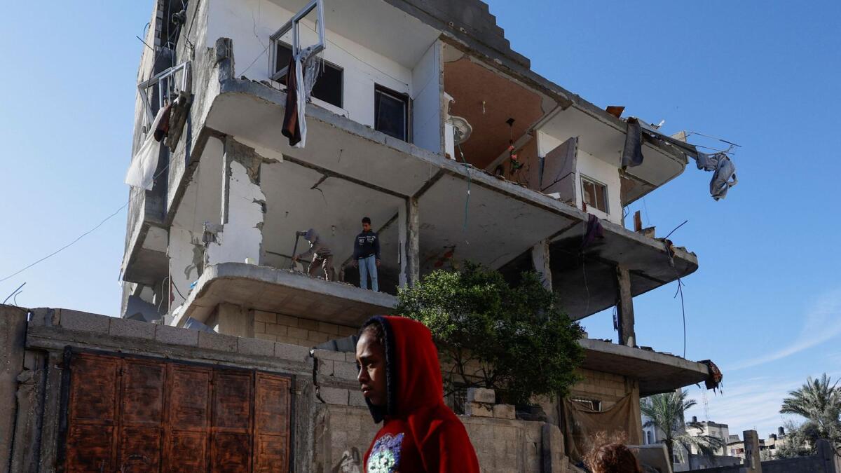 Palestinians walk near the site of an Israeli strike on a house, amid the ongoing conflict between Israel and the Palestinian Islamist group Hamas, in Rafah. — Reuters