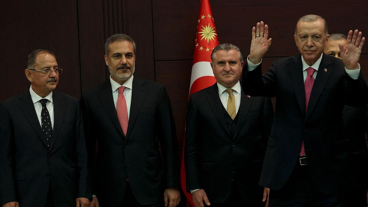 Turkey's President Recep Tayyip Erdogan waves next to the new Environment, Urbanization and Climate Change Minsiter Mehmet Ozhaseki (L) and new Foreign Minister Hakan Fidan  (2ndL) as he unveils the country's new cabinet at Cankaya Palace after he was sworn in as President in Parliament in Ankara on June 3, 2023.  -- AFP