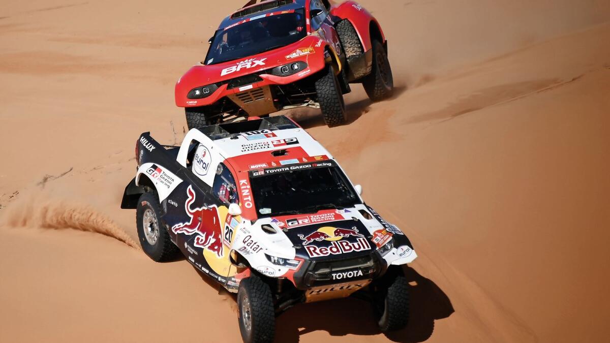 Qatar's Nasser Al Attiyah and co-driver Mathieu Baumel of France drive in front of Frenchman Sebastien Loeb and co-driver Fabian Lurquin of Belgium during Stage 5 of the Dakar on Thursday. — AFP