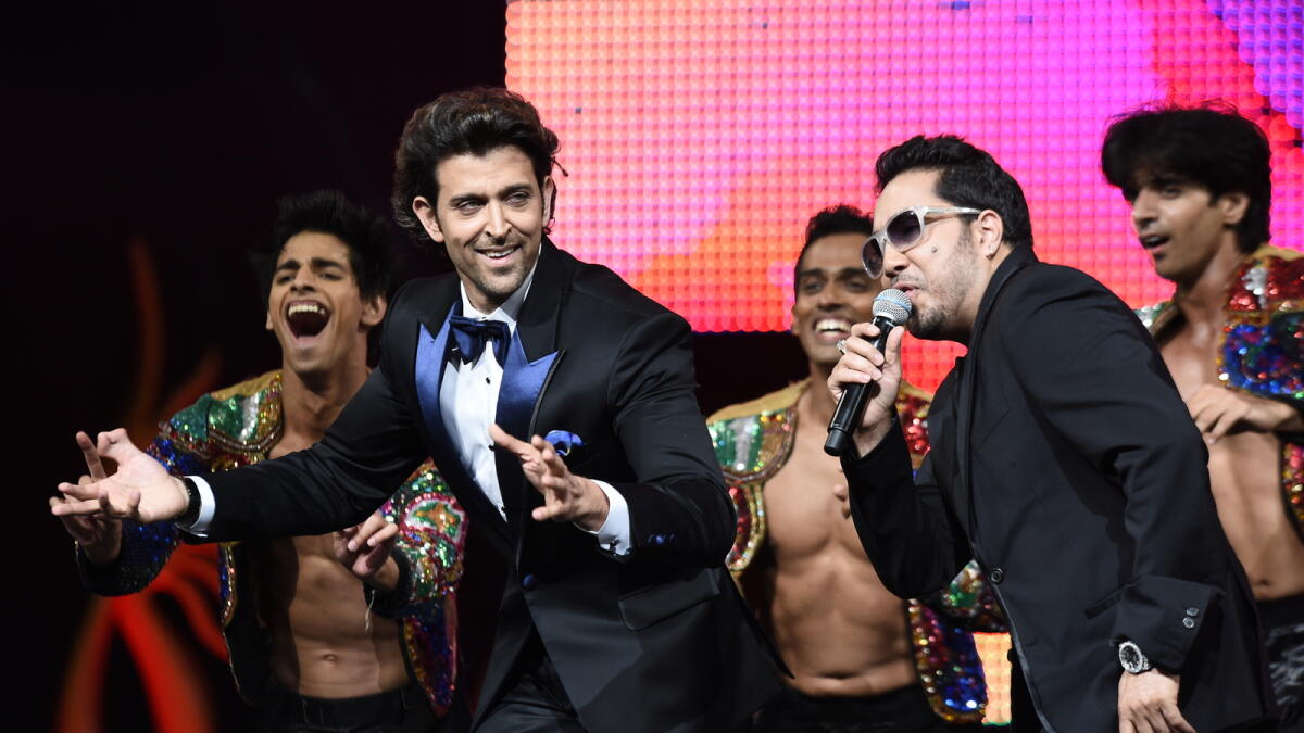 Bollywood actor Hrithik Roshan (2nd L) dances with Mika Singh on stage at the Mid Florida Credit Union Amphitheater during the IIFA Magic of the Movies show on the third day of the 15th International Indian Film Academy (IIFA) Awards in Tampa, Florida, April 25, 2014. AFP PHOTO JEWEL SAMAD / AFP PHOTO / JEWEL SAMAD