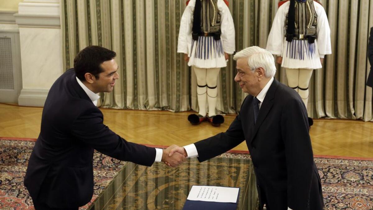 Leftwing leader Alexis Tsipras, left, shakes hands with President Prokopis Pavlopoulos after being sworn in as prime minister at the presidential palace in Athens on September 21, 2015. 