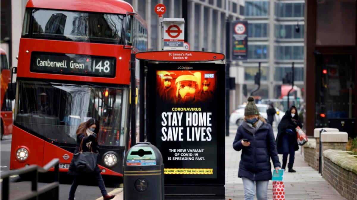 A digital display at a bus station warns pedestrians of the new strain of coronavirus in central London. — AFP