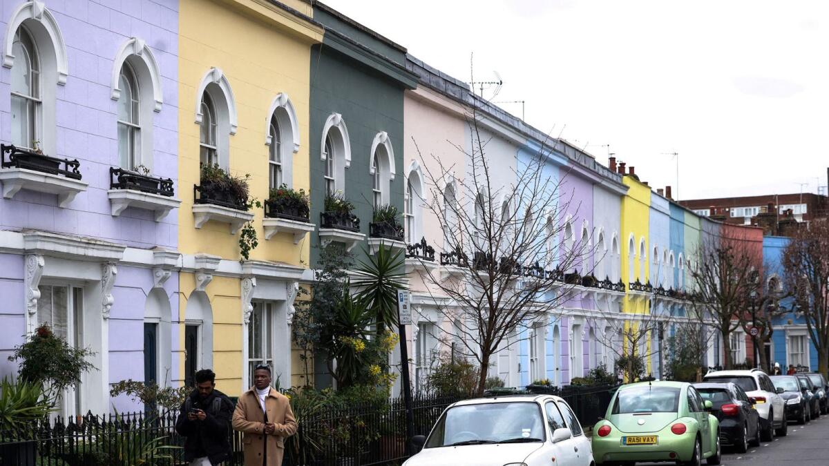People walk past a row of colourful houses in London, Britain, on March 19, 2023. — Reuters file photo used for illustrative purpose only