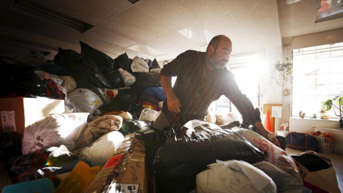 Volunteer Waleed Yousuf sorts through a pile of donations for Syrian refugees who are expected to arrive in Canada, at the Middle Eastern Friendship Centre in Surrey, British Columbia.