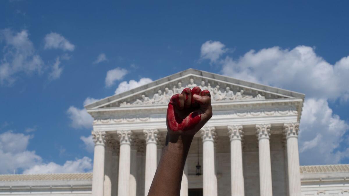 An abortion rights demonstrator raises their fist, painted in red, in the air while yelling during a rally in front of the US Supreme  Court in Washington, DC, on June 25, 2022. Photo: AFP