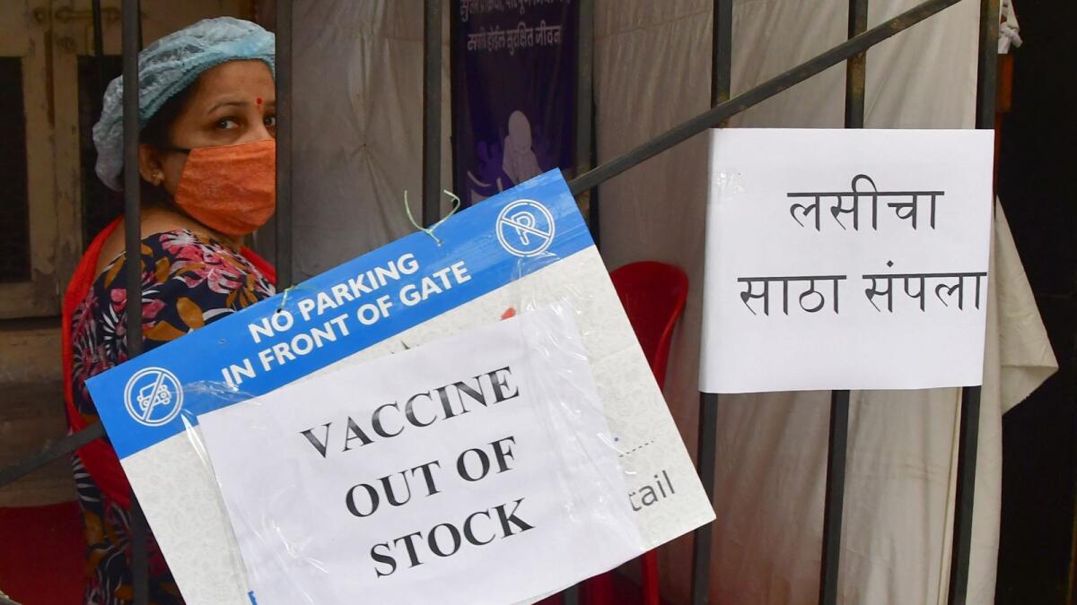 A woman stands next to a sign reading 'vaccine out of stock' at a vaccination in Mumbai. Photo: AFP