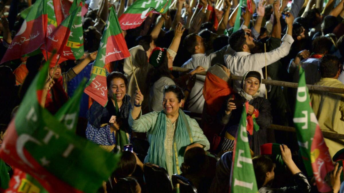 Supporters of Imran Khan wave flags during an anti-government protest rally in Islamabad. — AFP