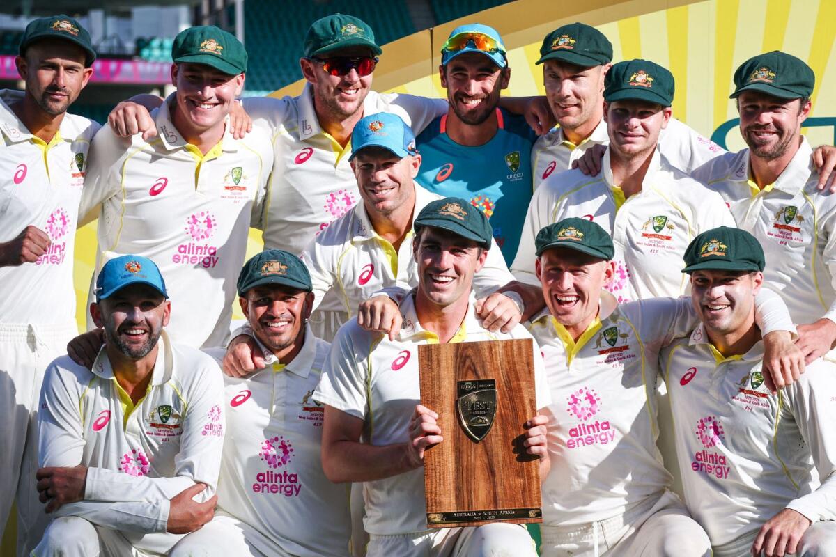 Australia captain Pat Cummins (centre) holds the trophy as he poses with teammates after the third Test against South Africa. — AFP