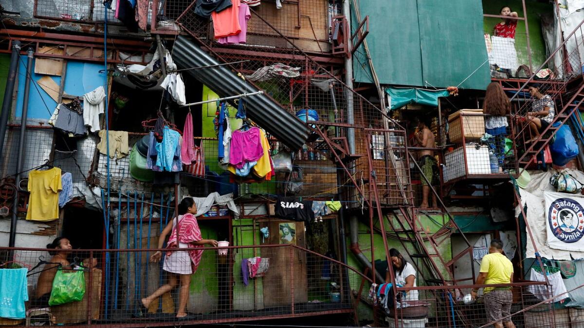 Residents of a small apartment building do house chores outside their units amid the lockdown to contain the coronavirus disease in Manila, on May 4. — Reuters file